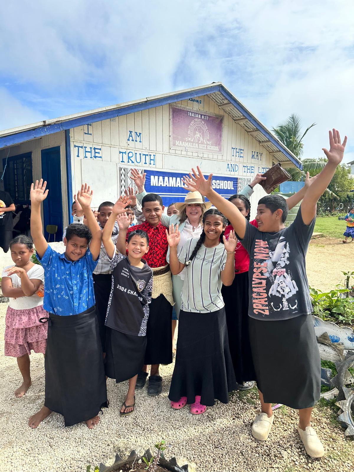 Ivonne A-Baki with children outside a school